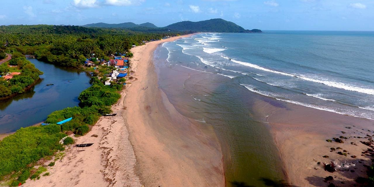 An empty stretch of golden sand and surf in South Goa